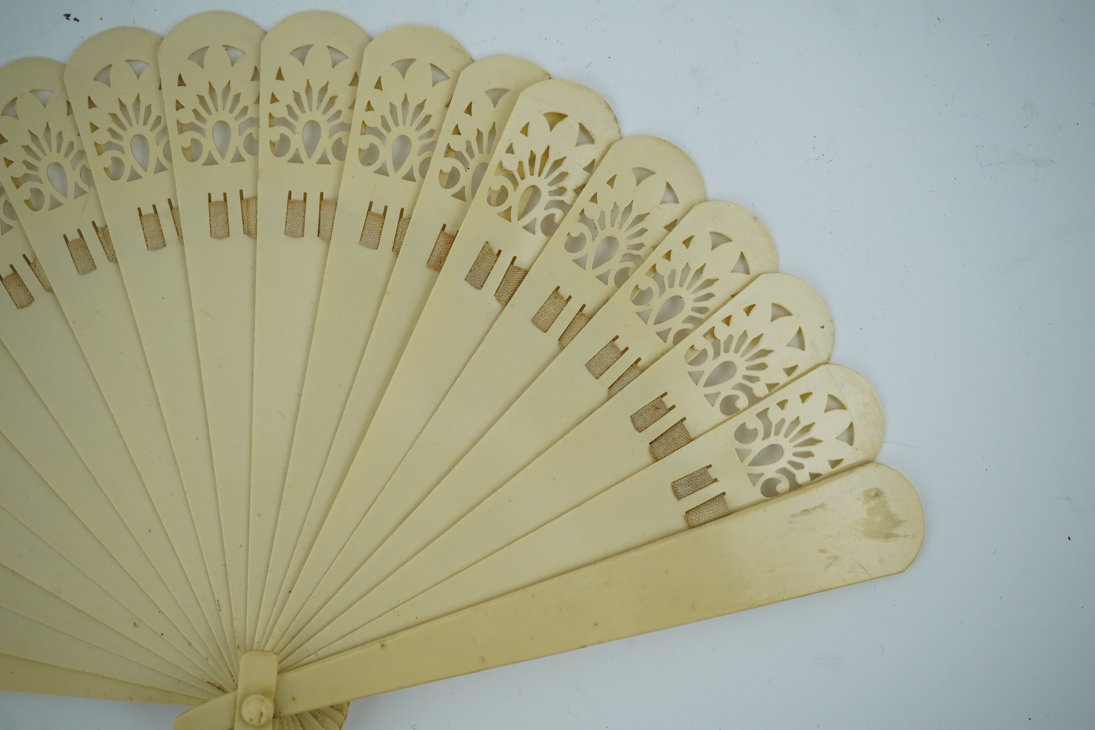 Three novelty fans with a mixed Brussels lace fan and black lace fan, a small language of love in flowers fan, a paper windmill advertising French Café fan, a carved cream Bakelite fan, a black and gilt, lace and sequin